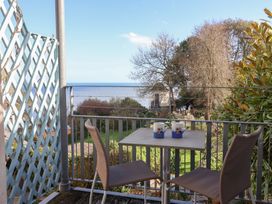 A balcony with table and chairs overlooking the sea at 2 St Michaels House Lyme Regis