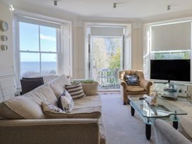 A living room with a sofa and a television at 2 St Michaels House in Lyme Regis
