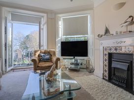 A living room with a television and a sofa at 2 St Michaels House in Lyme Regis