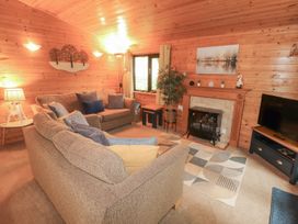 A living room with a sofa and fireplace at Derwent Lodge in Keswick