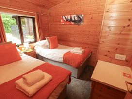 A bedroom with two beds and wooden features at Derwent Lodge in Keswick