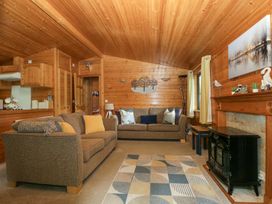A living room with a sofa and fireplace at Derwent Lodge in Keswick