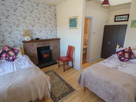 A bedroom with two beds and a fireplace at Sea View House, Tully, County Galway