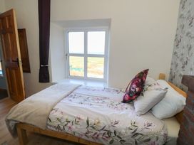 A bedroom with a bed and window at Sea View House Tully, County Galway