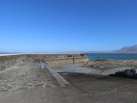 A view of a pier with benches by the water at Sea View House in Tully, County Galway