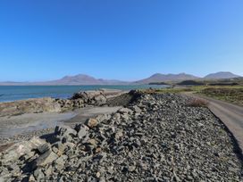 A coastal view with a rocky shoreline and mountains at Sea View House in Tully, County Galway