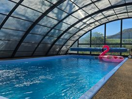 An indoor pool with a flamingo inflatable at The Keepers Lodge in Boduan near Nefyn