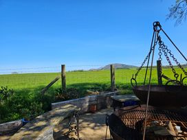 An outdoor area with a fire pit and view of a field at The Keepers Lodge in Boduan near Nefyn