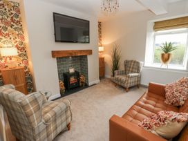 A living room with furniture and a television at Millside View