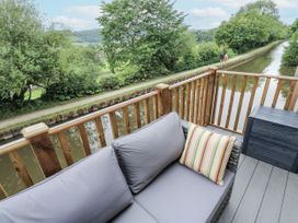 A sofa with a cushion overlooking a canal at Millside View 