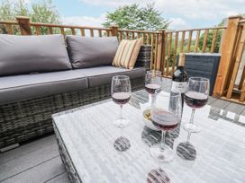 An outdoor seating area with a sofa and a table with wine and olives at Millside View 