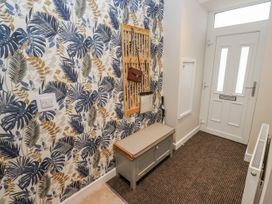 A hallway with a bench and decorative wall at Millside View