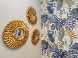 Three decorative mirrors on a patterned wall at Millside View