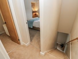 A hallway with a view of a staircase and a bedroom at Millside View 