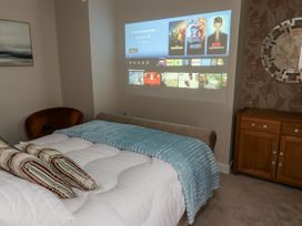 A bedroom with a bed and a projector display at Millside View 