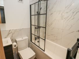 A bathroom with a shower, bathtub, toilet, and sink at Millside View