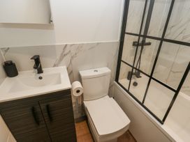 A bathroom with a toilet, sink, and shower at Millside View