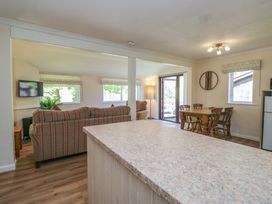 A living room with a couch and television at Chestnut Timber Lodge in Keswick