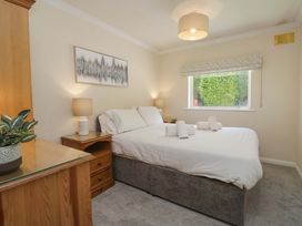 A bedroom with a bed and bedside lamps at Chestnut Timber Lodge in Keswick