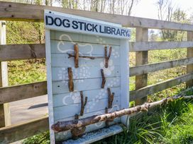A dog stick library with wooden sticks attached in a park at Chestnut Timber Lodge in Keswick