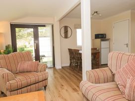 A living room with a sofa, table, and fridge at Dogwood Timber Lodge, Keswick