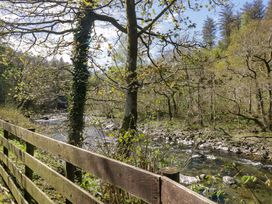A river with trees and fence at Dogwood Timber Lodge in Keswick