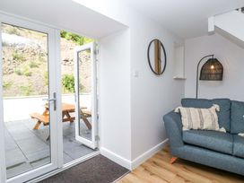 A living room with doors leading to outdoor seating at Riverside Cottage No 4 in Keswick