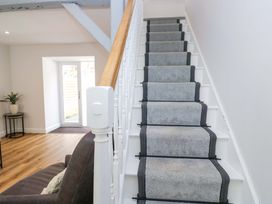 A staircase with a handrail leading to a door at Riverside Cottage No 4 in Keswick