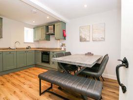 A kitchen with cabinets and dining table at Riverside Cottage No 4 in Keswick