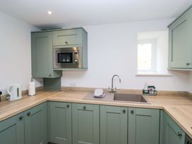 A kitchen with cabinets and appliances at Riverside Cottage No 4 in Keswick