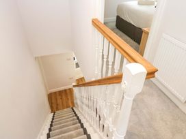 A staircase with a handrail and carpet at Riverside Cottage No 4 in Keswick