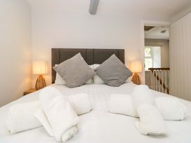 A bedroom with a bed, pillows, and towels at Riverside Cottage No 4 in Keswick