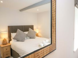 A bedroom with a bed, nightstands, lamps, and towels at Riverside Cottage No 4 in Keswick