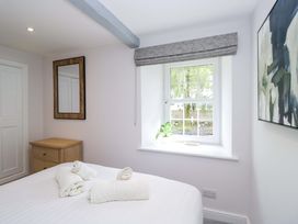 A bedroom with a bed and a mirror at Riverside Cottage No 4 in Keswick