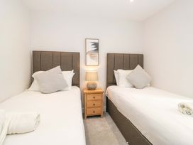 A bedroom with two single beds and a bedside table at Riverside Cottage No 4 in Keswick