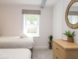 A bedroom with two beds and a dresser at Riverside Cottage No 4, Keswick