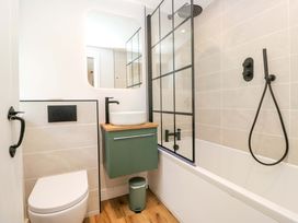 A bathroom with a shower, bathtub, sink and toilet at Riverside Cottage No 4, Keswick