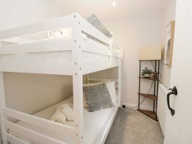 A bedroom with bunk beds and a lamp at Riverside Cottage No 4 in Keswick