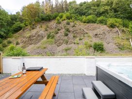 An outdoor area with a hot tub and seating at Riverside Cottage No 4 in Keswick