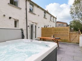 An outdoor area with a hot tub and table at Riverside Cottage No 4 in Keswick