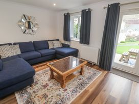 A living room with a blue sofa and coffee table at Chellowdene Cottage in Falmouth