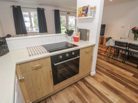 A kitchen with cabinets and an oven at Chellowdene Cottage in Falmouth