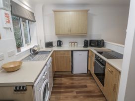 A kitchen with cabinets and appliances at Chellowdene Cottage in Falmouth