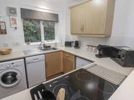 A kitchen with appliances and sink at Chellowdene Cottage in Falmouth