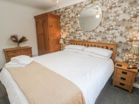 A bedroom with a bed and wardrobe at Chellowdene Cottage in Falmouth