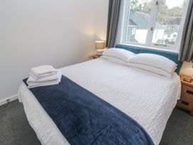 A bedroom with a bed and bedside tables at Chellowdene Cottage in Falmouth