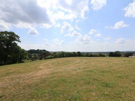 A grassy field with trees and clouds in the sky at The Coop in Aston near Woore