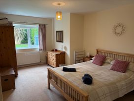 A bedroom with a bed and wardrobe at Jacuma in Rhosneigr