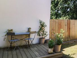 A table and chairs with flower pots on a wooden deck at 22 Applebee Way Lyme Regis