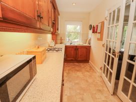 A kitchen with cabinets, a stove, and a sink at Flat 17 in Keswick